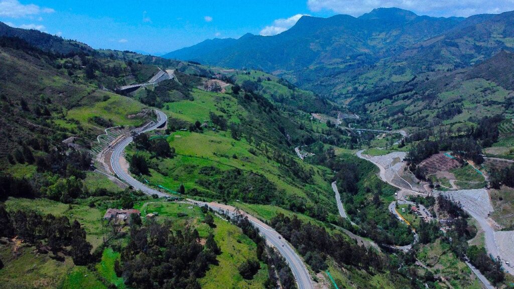 Photo of a winding mountain highway with hairpin turns in the Colombian Andes, showing steep terrain and long sightlines.
